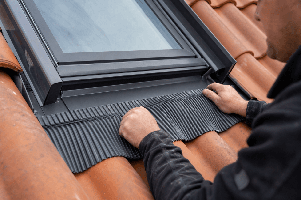 Raccord d'étanchéité autour d'une fenêtre de toit sur couverture en tuiles